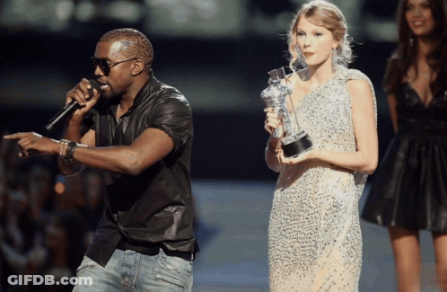 Man Singing Into Microphone Woman Holding Trophy GIF