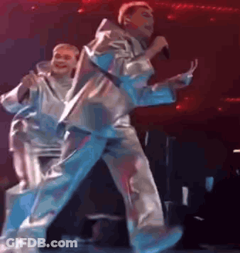 Man Singing On Stage With Dancer Behind GIF