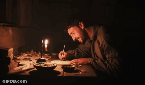 Man Sits At Table With Candle And Ash GIF