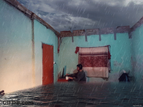 Man Sits In Flooded Room With Coffee GIF