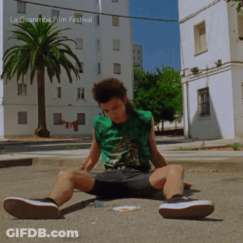 Man Sits On Gound Under Hot Sun GIF