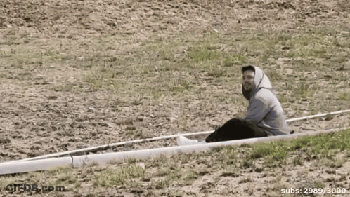 Man Sits On White Object With Number 3000 GIF