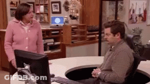 Man Sitting At Computer Desk With Woman Standing Next GIF