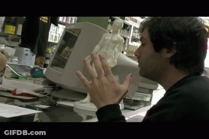 Man Sitting At Dell Computer Holding Statue GIF