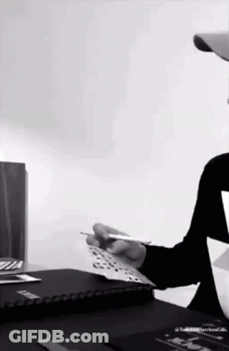 Man Sitting At Desk Holding Paper GIF