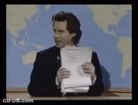 Man Sitting At Desk Holding Paper GIF