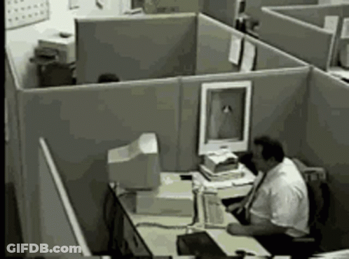 Man Sitting At Desk In Office Cubicle With Computer GIF