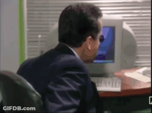 Man Sitting At Desk Looking At Microsoft Computer Screen GIF