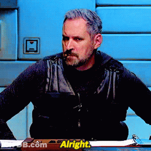 Man Sitting At Desk With Alright Sign GIF