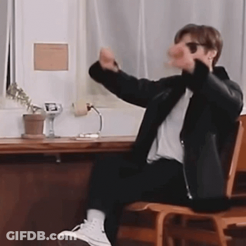 Man Sitting At Desk With Arms Outstretched GIF