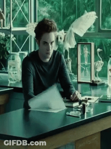 Man Sitting At Desk With Bird In Glass Case GIF