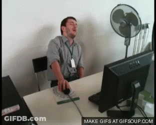 Man Sitting At Desk With Computer And Fan GIF