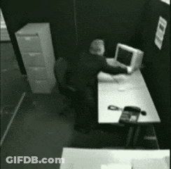 Man Sitting At Desk With Computer And Phone GIF