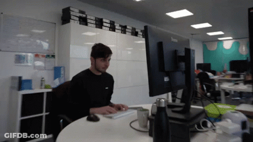 Man Sitting At Desk With Lenovo Monitor GIF