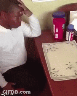 Man Sitting At Desk With Tylenol Bottle GIF