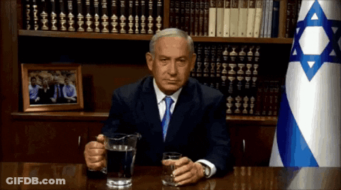 Man Sitting At Desk With Water Pitcher And Flag GIF