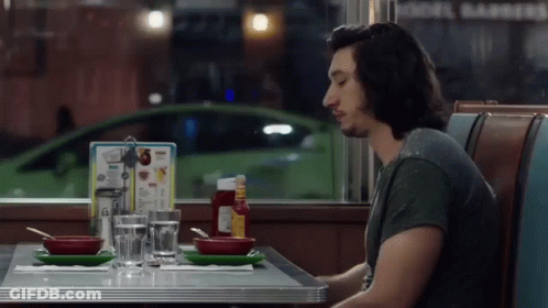Man Sitting At Diner Table With Menu GIF