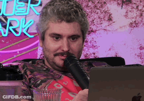 Man Sitting At Laptop With Microphone And After Park Neon Sign GIF