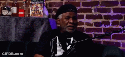 Man Sitting At Microphone By Brick Wall GIF