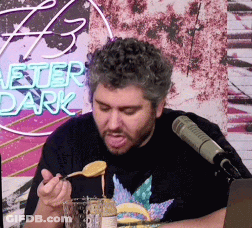 Man Sitting At Microphone Eating From Spoon GIF