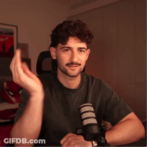 Man Sitting At Microphone Hand Outstretched GIF