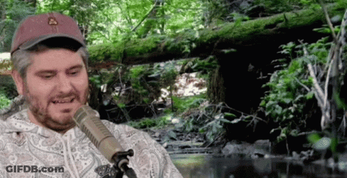 Man Sitting At Microphone In Forest GIF