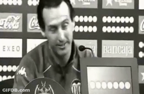 Man Sitting At Podium With Coca-Cola Bancaja Logos GIF