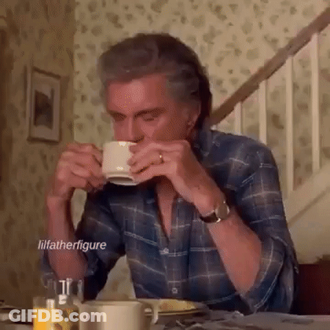 Man Sitting At Table Drinking From Cup GIF