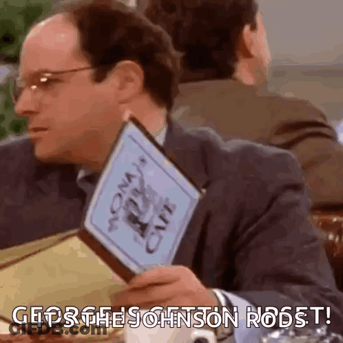 Man Sitting At Table Holding Menu GIF