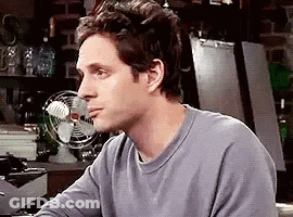 Man Sitting At Table In Front Of Fan GIF