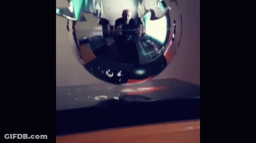 Man Sitting At Table In Front Of Floating Sculpture GIF