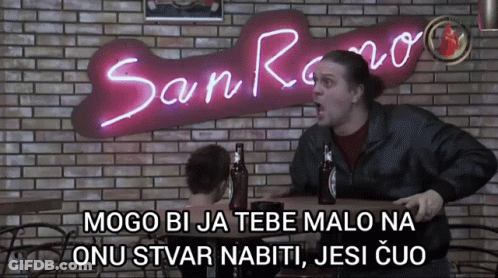 Man Sitting At Table In Front Of San Reno Sign GIF