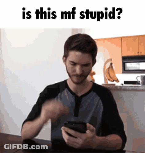 Man Sitting At Table Looking At Cell Phone GIF