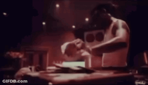 Man Sitting At Table Playing Music In Dark Room GIF