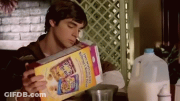 Man Sitting At Table Reading Cereal Box Drinking Milk GIF