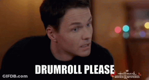 Man Sitting At Table Saying Drumroll Please GIF
