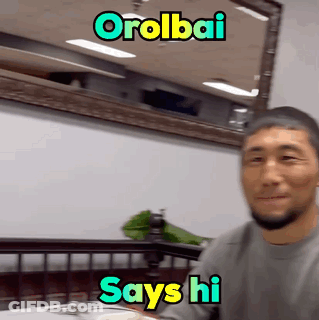 Man Sitting At Table Saying Hi GIF