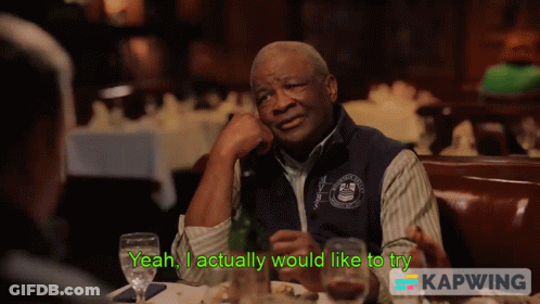 Man Sitting At Table Saying Yeah I Actually Would Like To Try GIF