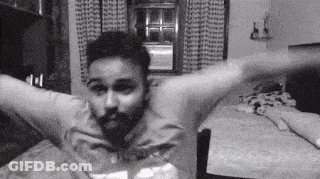 Man Sitting At Table With Arms Outstretched GIF