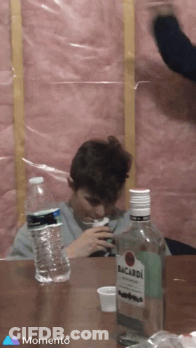 Man Sitting At Table With Bacardi Bottle GIF