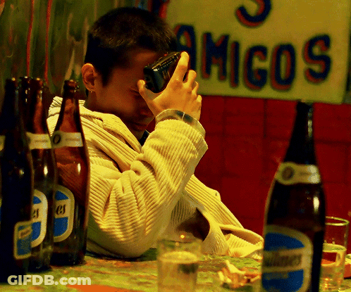 Man Sitting At Table With Beer And Amigos Sign GIF