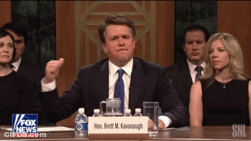 Man Sitting At Table With Brett M. Kavanagh Sign GIF
