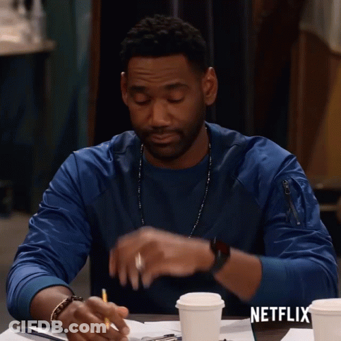 Man Sitting At Table With Coffee And Netflix Logo GIF