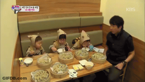 Man Sitting At Table With Food And KBS Sign GIF