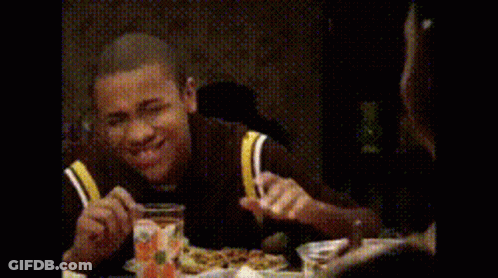 Man Sitting At Table With Hands In Air GIF
