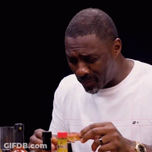 Man Sitting At Table With Hot Sauce And Pizza GIF