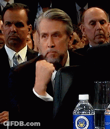 Man Sitting At Table With Lamp And Flowers GIF