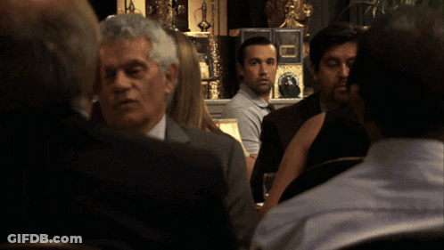 Man Sitting At Table With Lamp And Flowers GIF