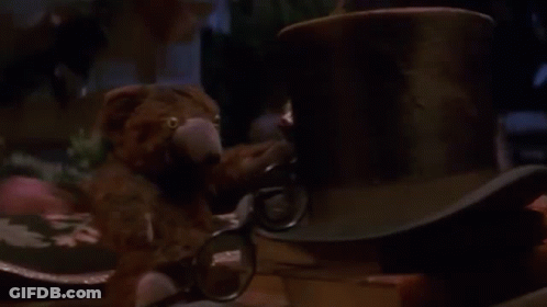 Man Sitting At Table With Lamp And Stuffed Animal GIF