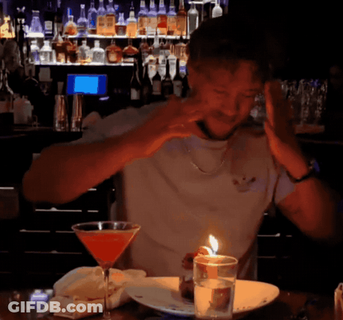 Man Sitting At Table With Martini And Candle GIF